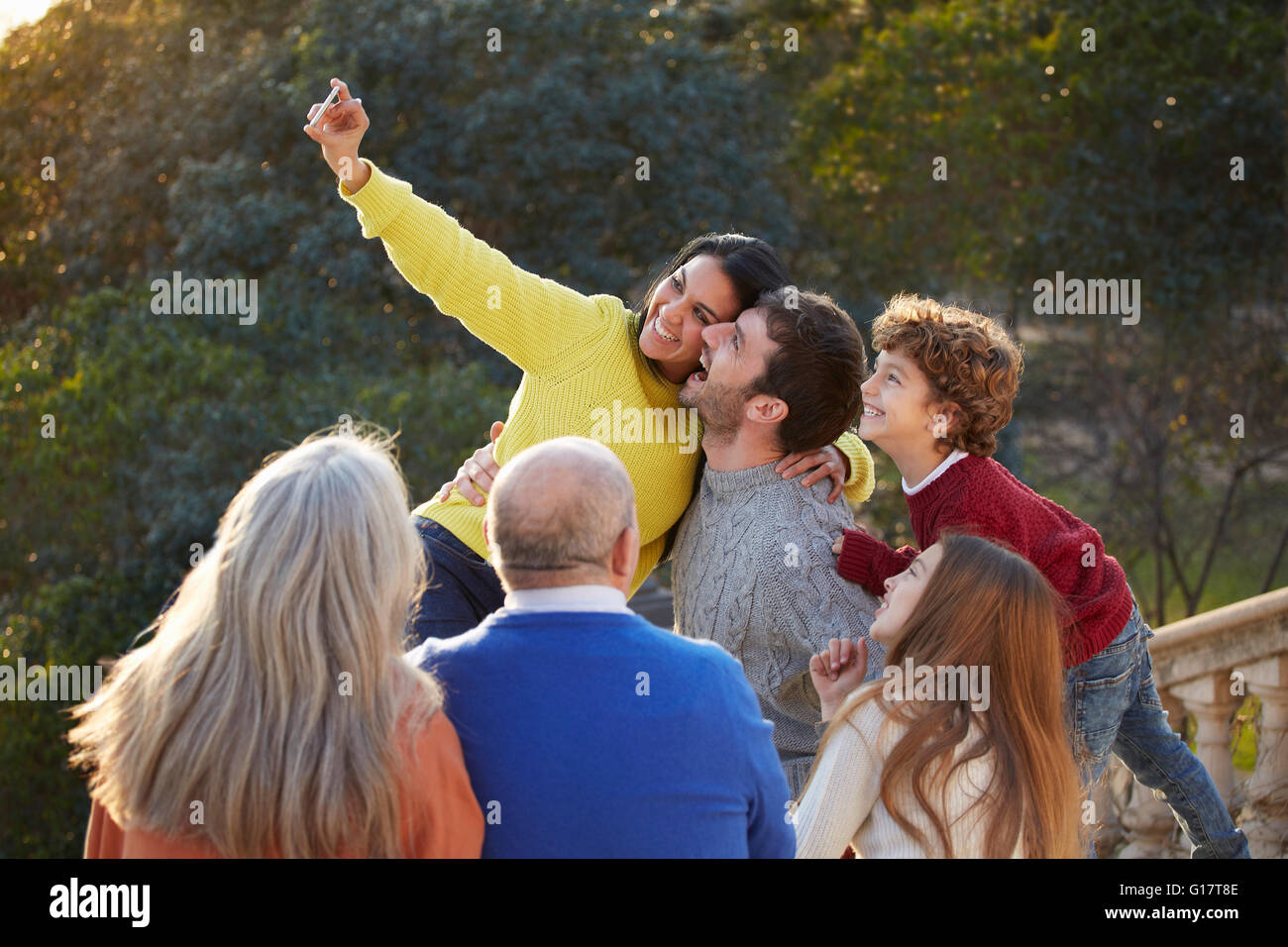 Metà donna adulta e la famiglia utilizza lo smartphone per prendere selfie in posizione di parcheggio Foto Stock