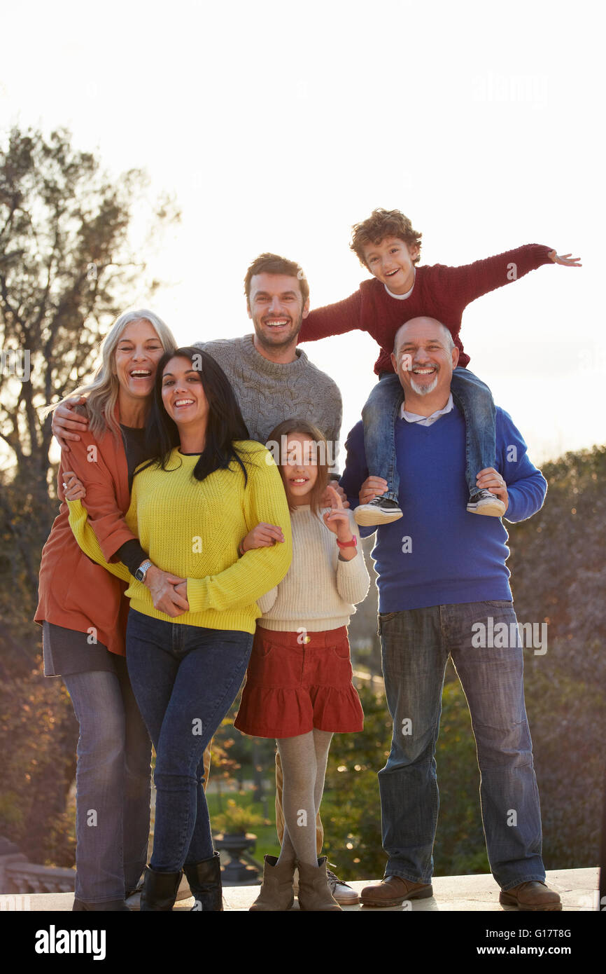 Multi familiare di generazione in posa per la fotografia nel parco, guardando alla fotocamera a sorridere Foto Stock