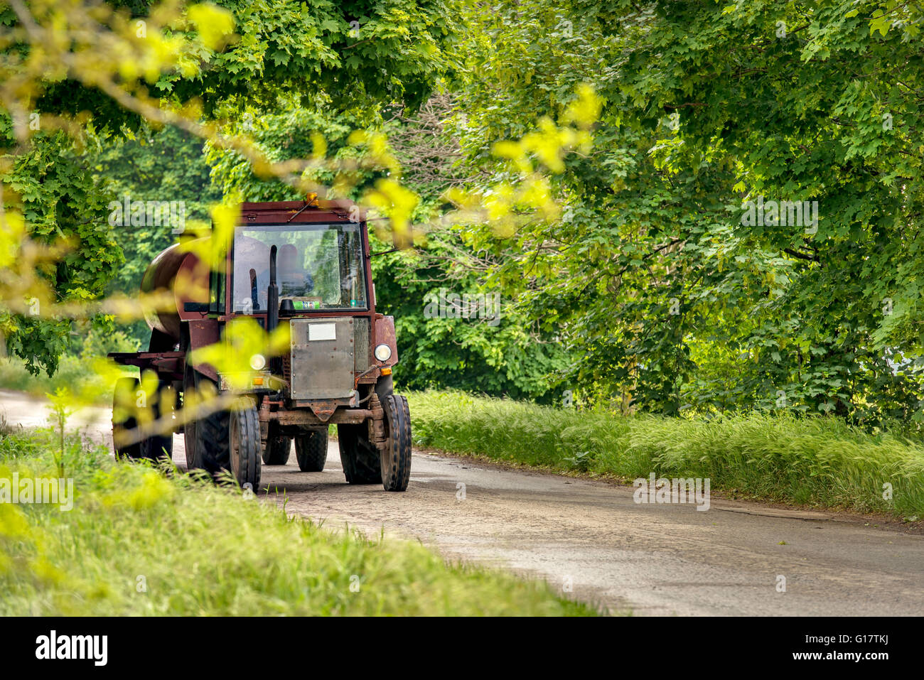 Agricoltore aziona il trattore su strada! Foto Stock