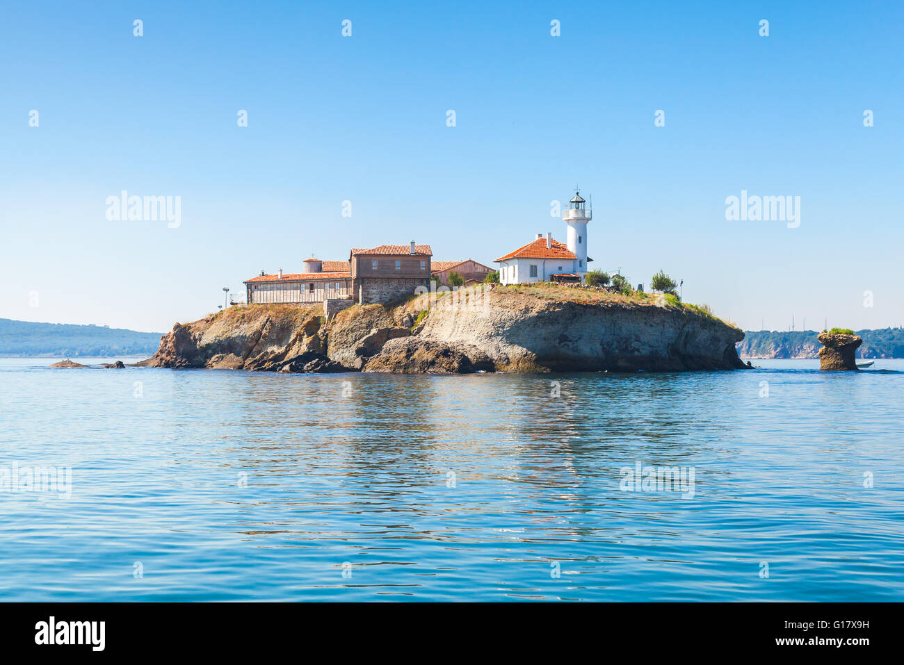 Santa Anastasia isola nella baia di Burgas, Mar Nero, Bulgaria. Torre faro e vecchi edifici in legno sulla costa rocciosa Foto Stock