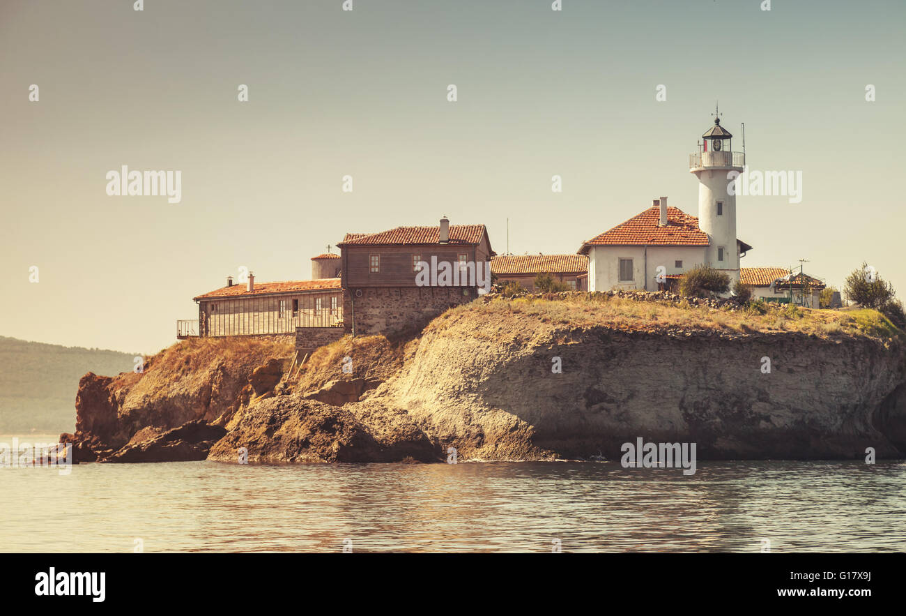 Faro e vecchi edifici in legno su Santa Anastasia isola. Burgas Bay, Mar Nero, Bulgaria. Vintage tonale filtro di correzione Foto Stock