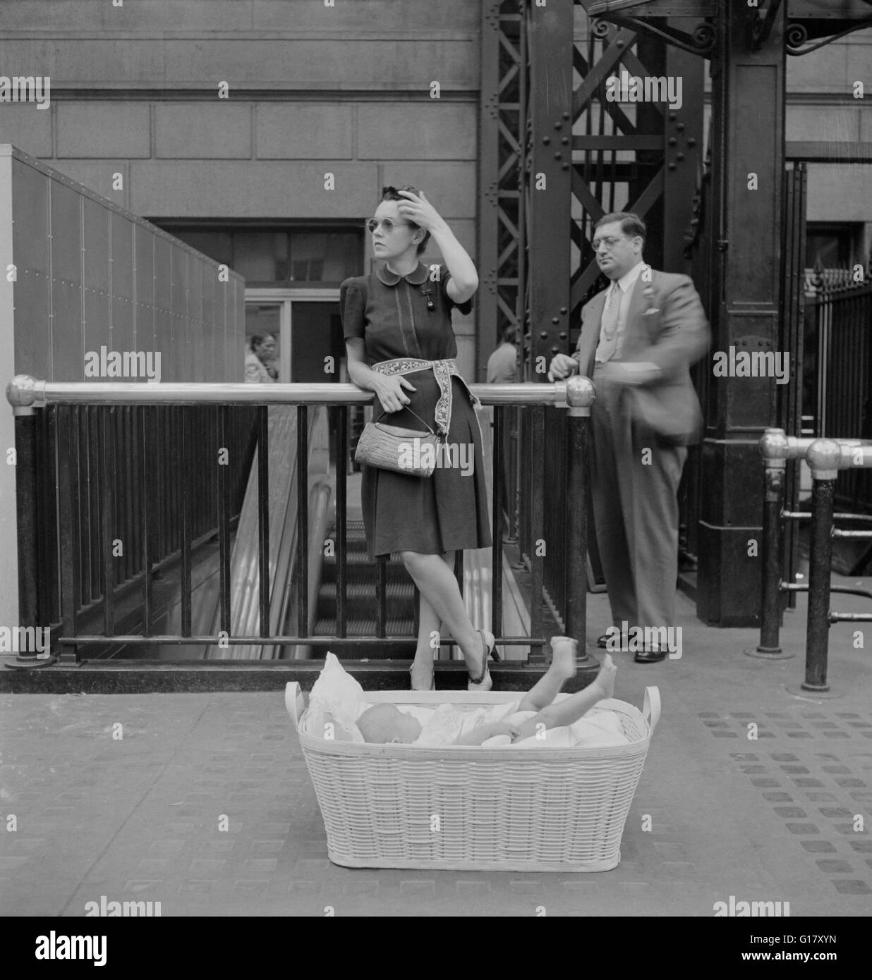 Donna con bambino nel cestello in attesa del treno, stazione di Pennsylvania, New York New York, Stati Uniti d'America, Marjorie Collins per l'Ufficio di informazione di guerra, Agosto 1942 Foto Stock