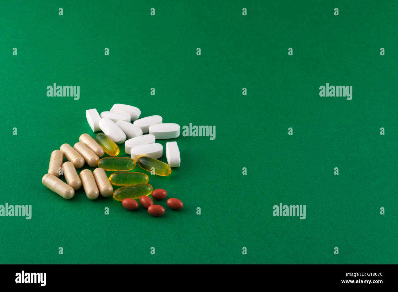Varie pillole di supplemento su sfondo colorato Foto Stock