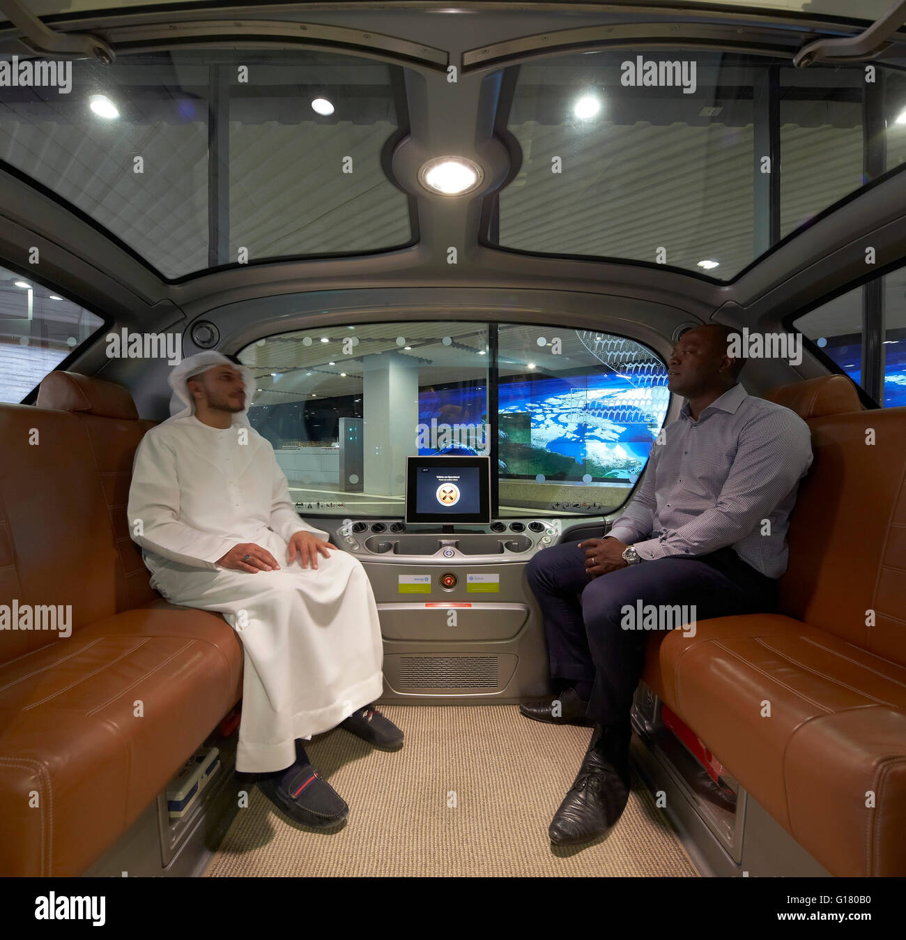 Passeggeri in Dymaxion Car. Masdar City, Masdar City, Emirati Arabi Uniti. Architetto: vari, 2014. Foto Stock