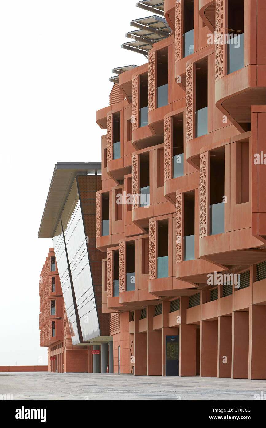 Prospettiva lungo la facciata in cotto. Masdar City, Masdar City, Emirati Arabi Uniti. Architetto: vari, 2014. Foto Stock