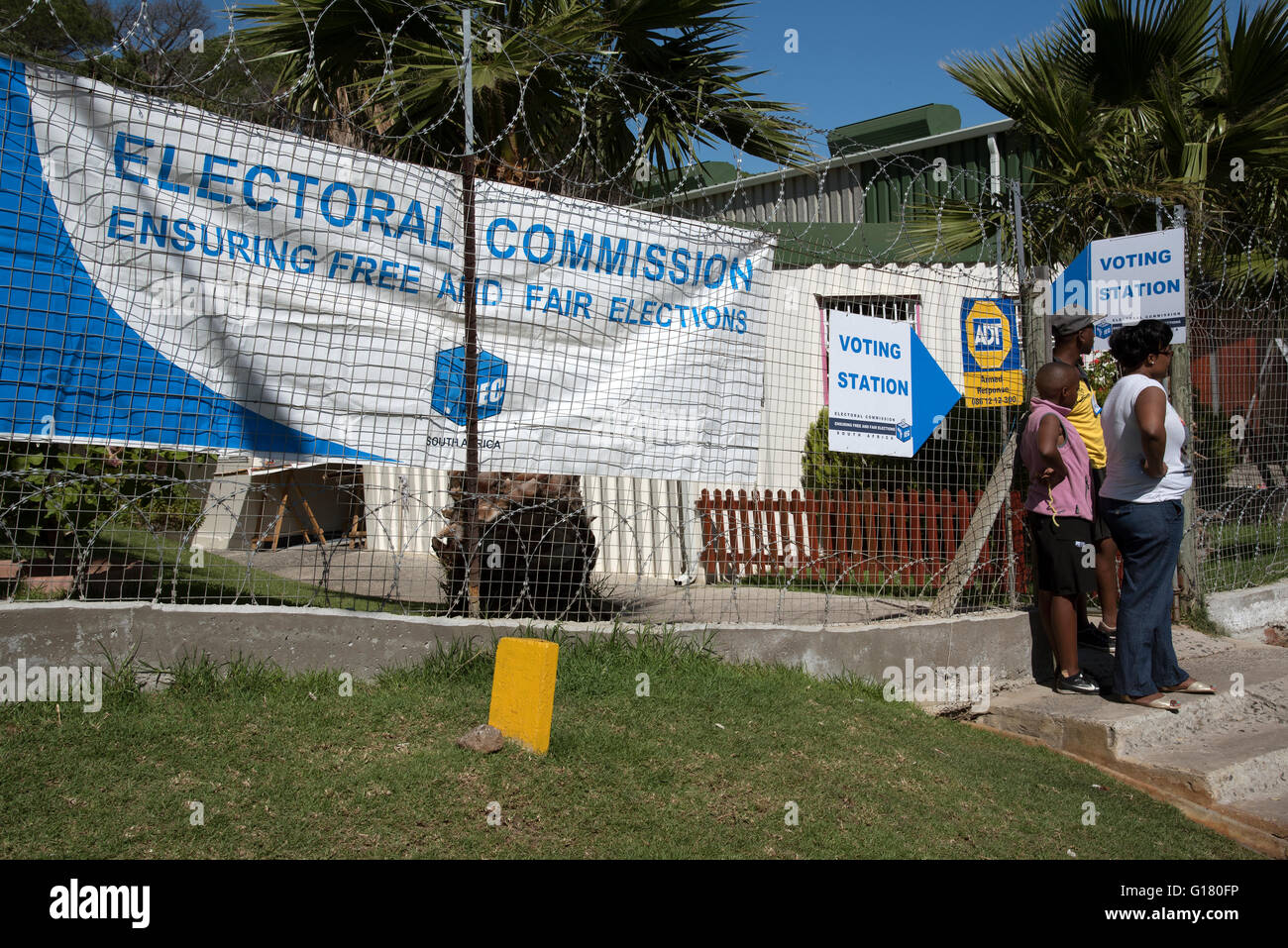 IMIZAMO YETHU TOWNSHIP Western Cape in Sud Africa. Stazione di votazione con le donne in piedi al di fuori del cancello Foto Stock