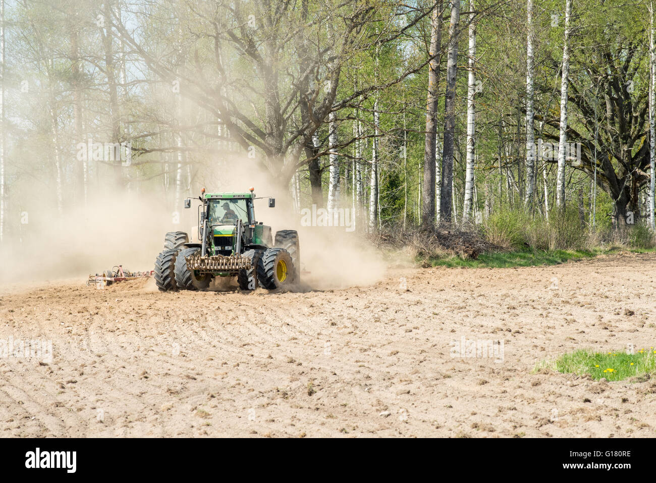 Il trattore arare i campi durante la primavera nella contea di Östergötland, Svezia. Foto Stock