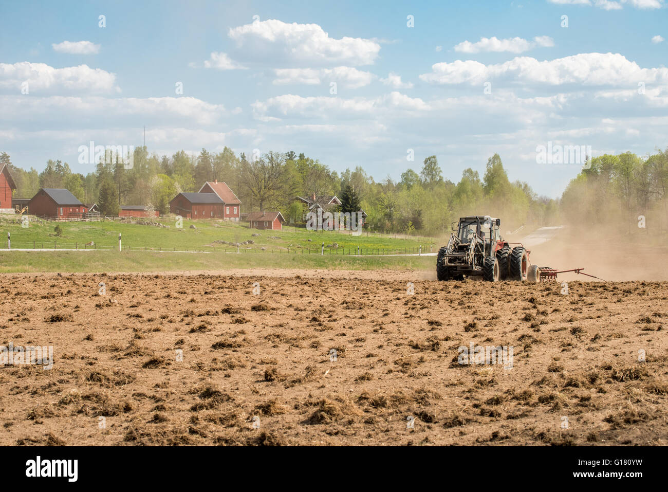 Il trattore arare i campi durante la primavera nella contea di Östergötland, Svezia. Foto Stock