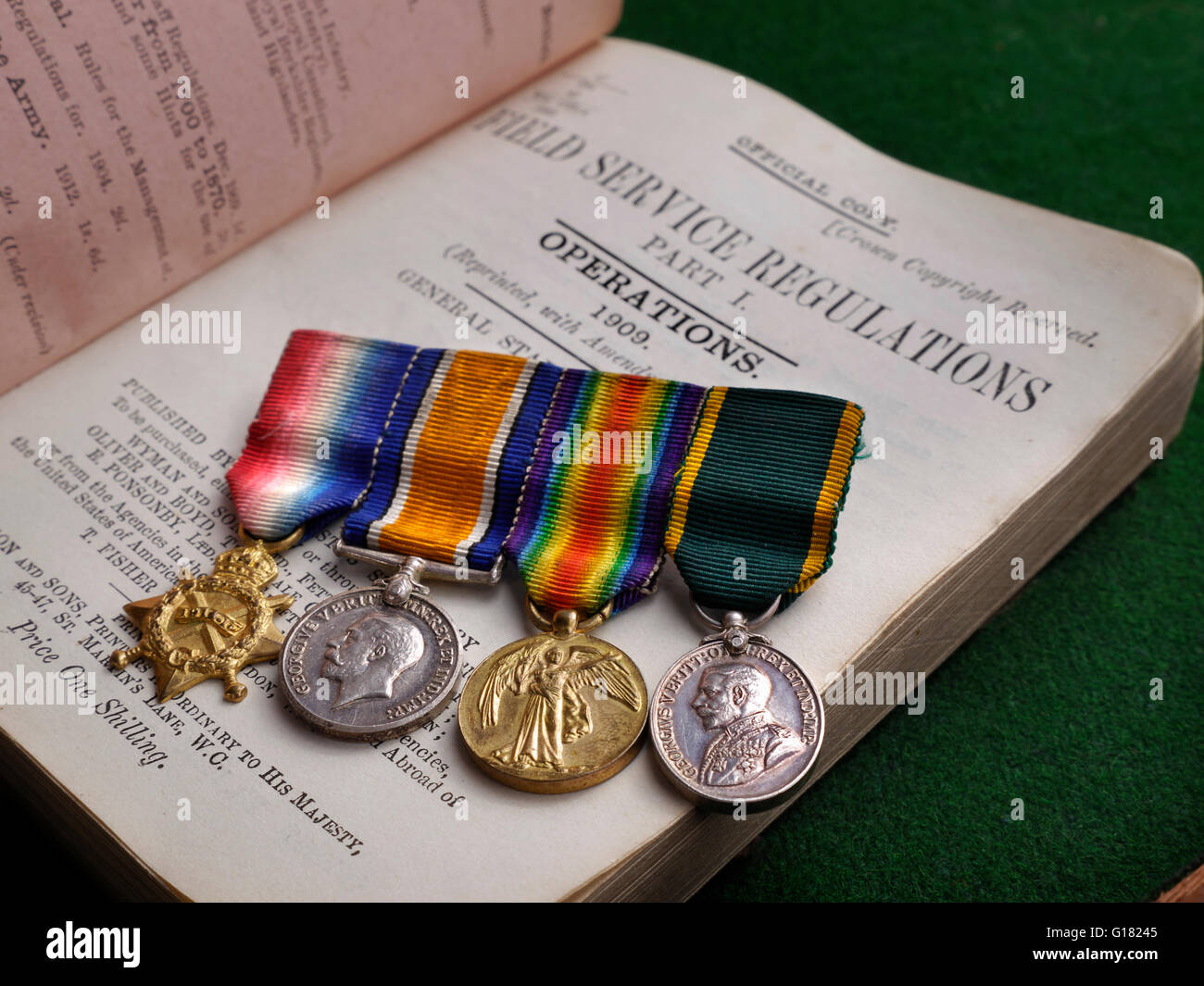 WW1 medaglie esercito britannico prima guerra mondiale medaglie su un campo di 1909 regolamenti di servizio manuale per servire i soldati dell'Esercito britannico Foto Stock
