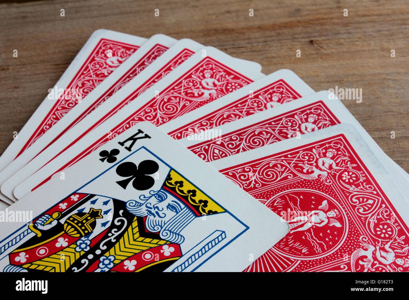 Red giocando a carte con il re del club. Foto Stock