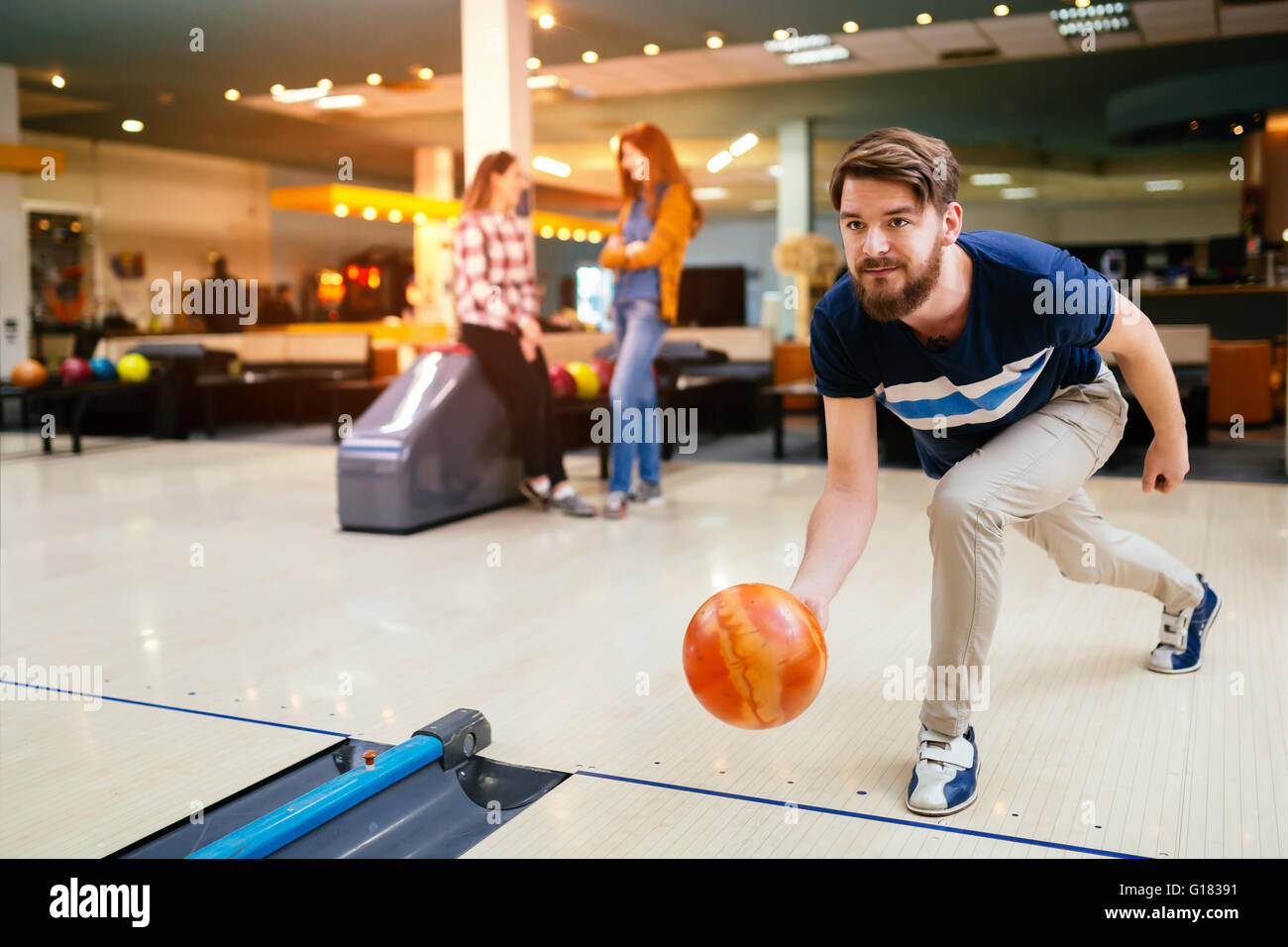 Uomo bello gettando palla da bowling Foto Stock