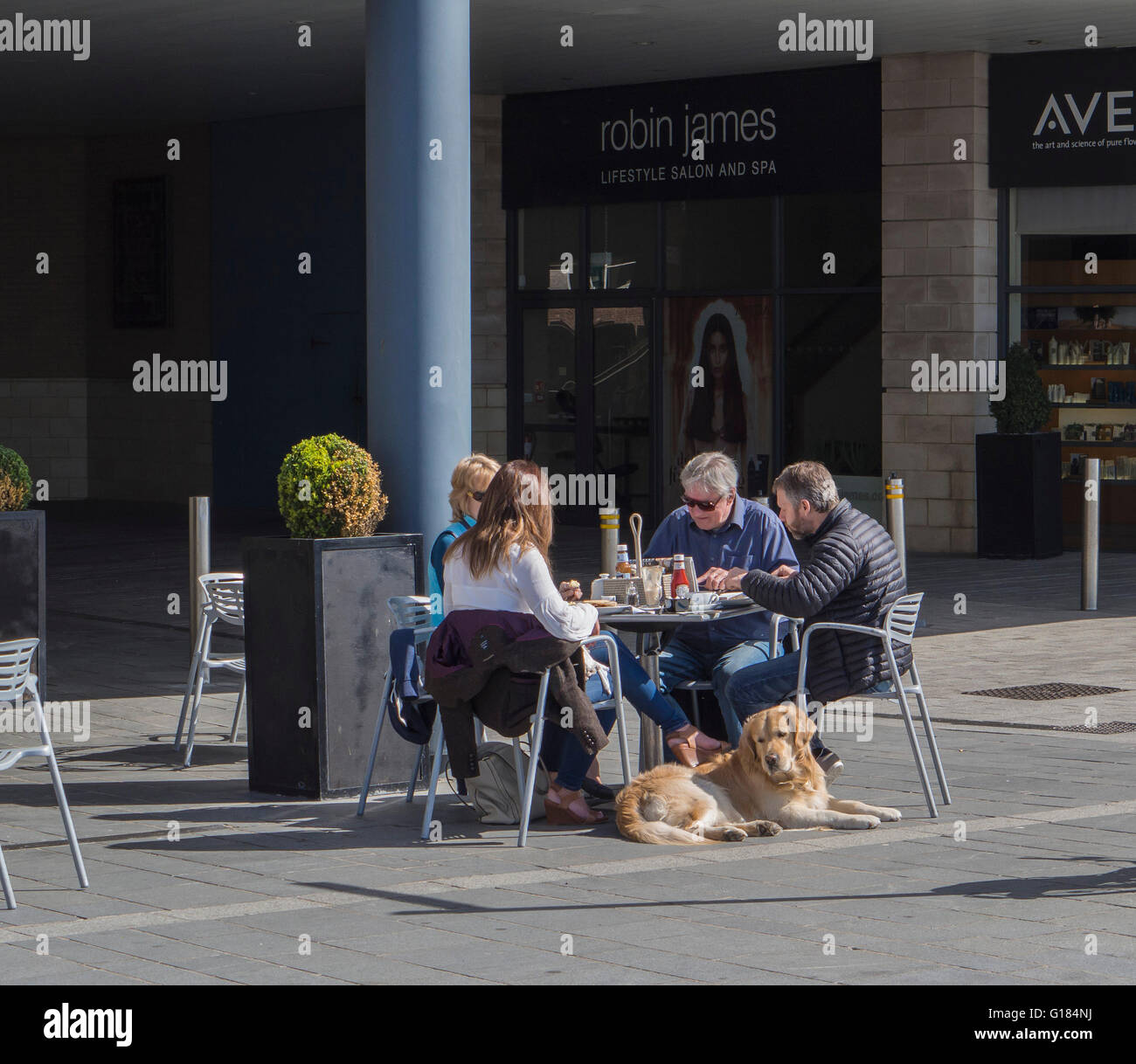 Quattro persone aventi un pasto a un tavolo al di fuori di un cafe a Poole Quay, REGNO UNITO Foto Stock