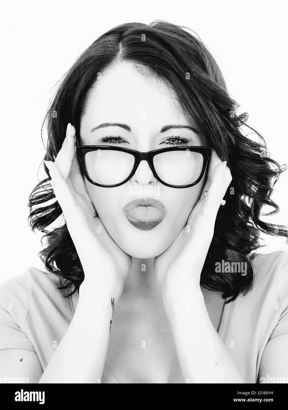 Ritratto di una donna con la lingua fuori in un giocoso gesto umoristico contro uno sfondo bianco Foto Stock