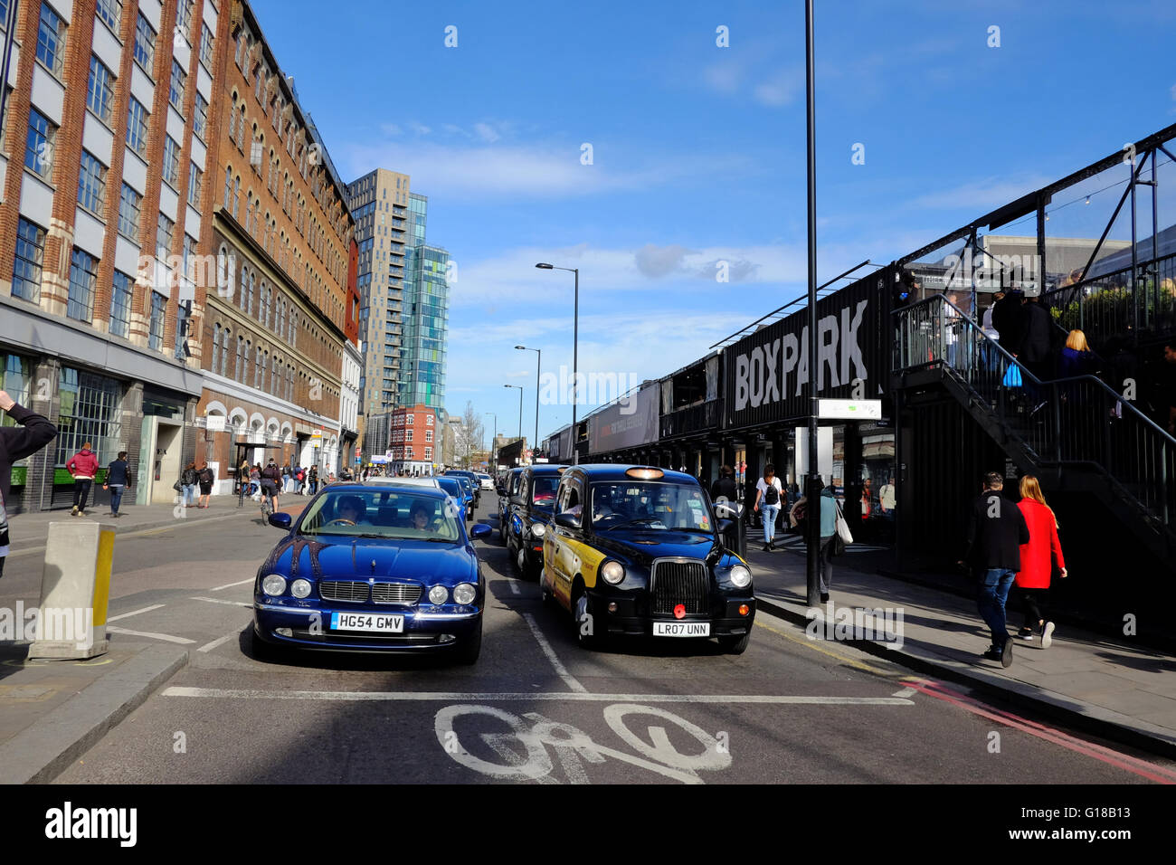 Taxi e automobili in attesa al semaforo dalla casella Parco in Shoreditch, Londra Foto Stock