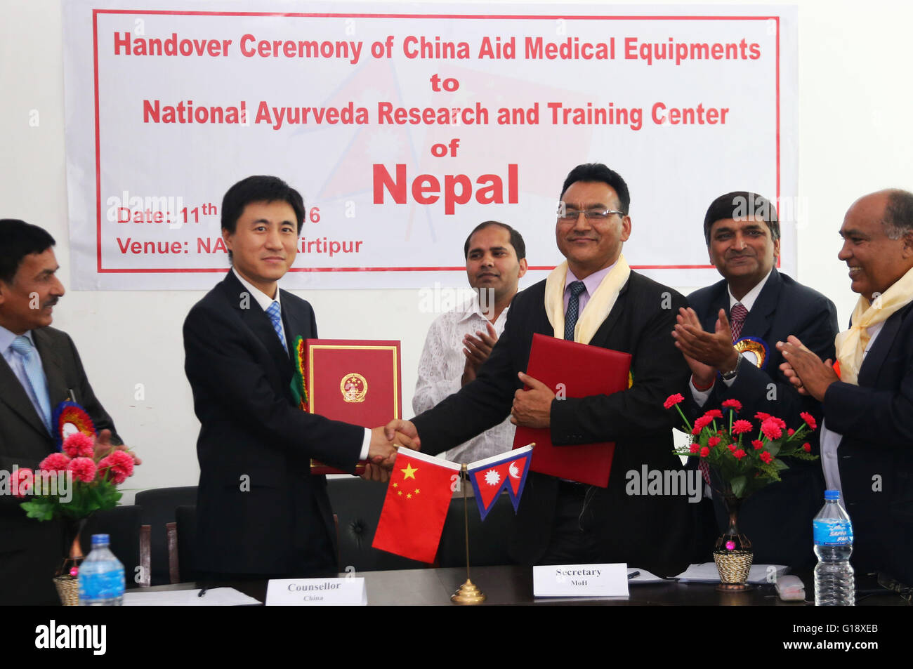 (160511) -- Kathmandu, 11 maggio 2016 (Xinhua) -- Peng Wei (2 L), consigliere economico dell'Ambasciata cinese in Nepal e Shanta Bahadur Shrestha che 3 (R), segretario presso il Ministero nepalese di sanità e popolazione, agitare le mani dopo la firma di documenti durante la cerimonia di consegna di attrezzature e materiale sanitario fornito dalla Cina all'Ayurveda Nazionale Centro di ricerca e formazione (NARTC) a Kathmandu, Nepal, 11 maggio 2016. (Xinhua/Sunil Sharma) Foto Stock