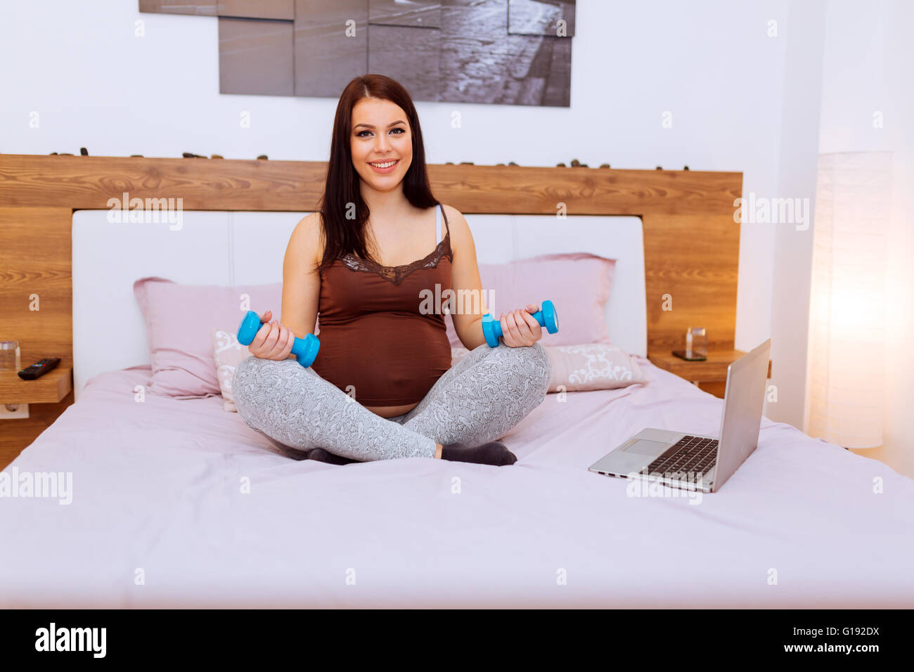 Donna incinta mantenendo il suo corpo montare durante la gravidanza Foto Stock