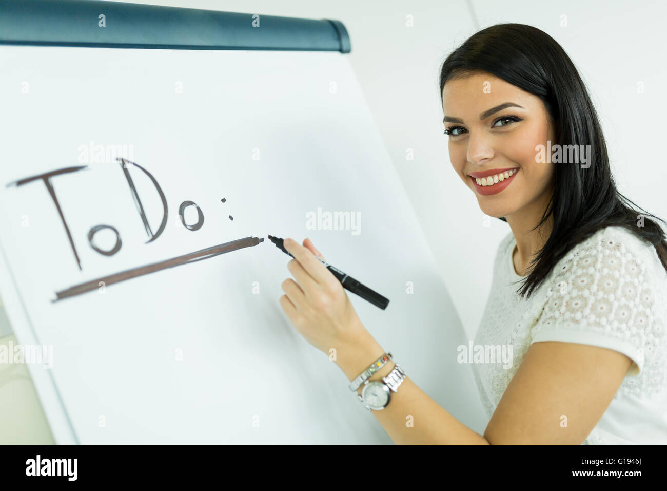 Bella e giovane imprenditrice iscritto todo su un bianco scheda di scrittura Foto Stock