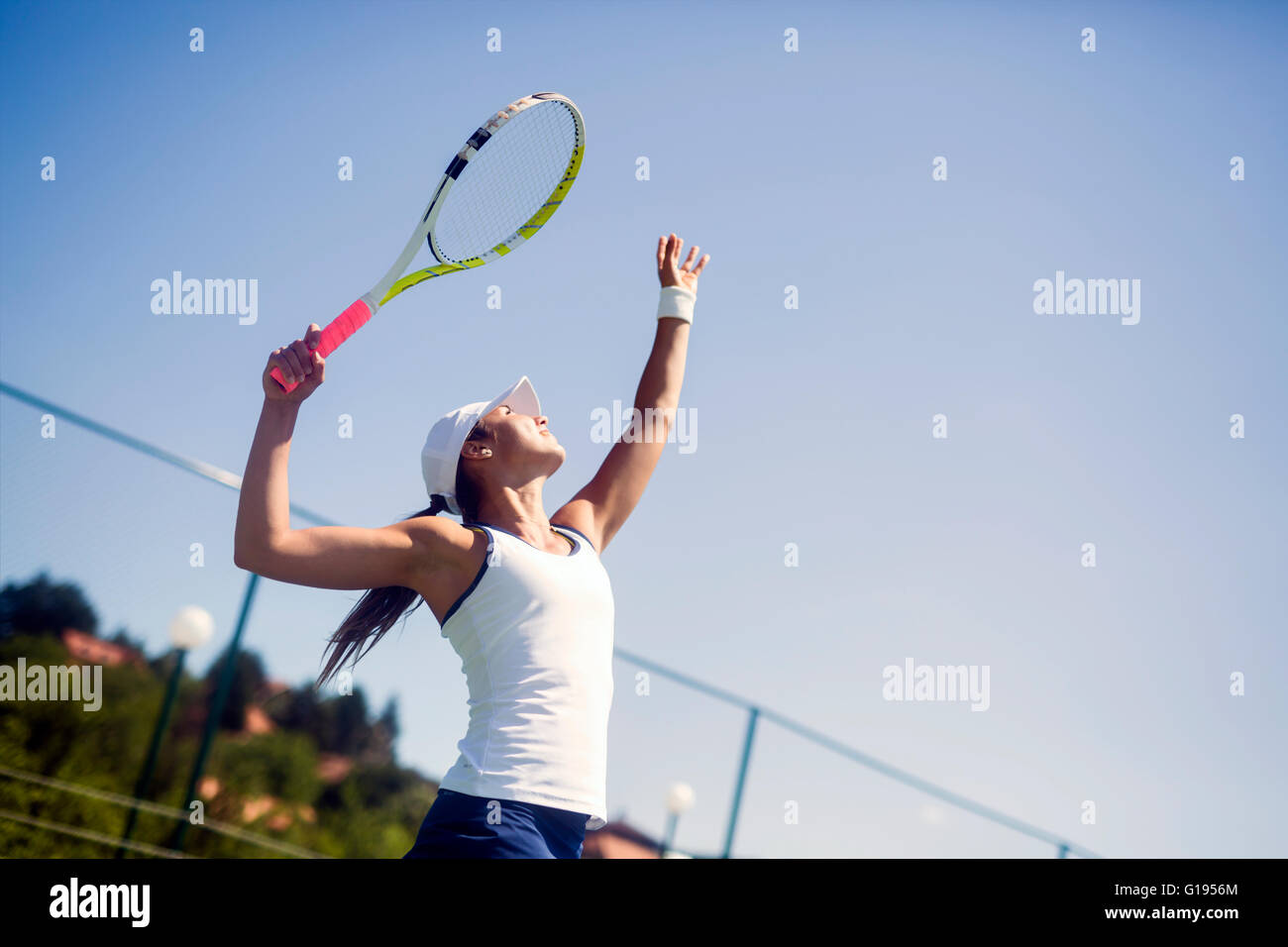 Bellissima femmina giocatore di tennis che serve per esterno Foto Stock