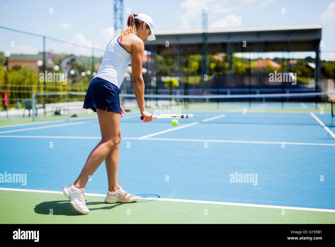 Bellissima femmina giocatore di tennis che serve per esterno Foto Stock