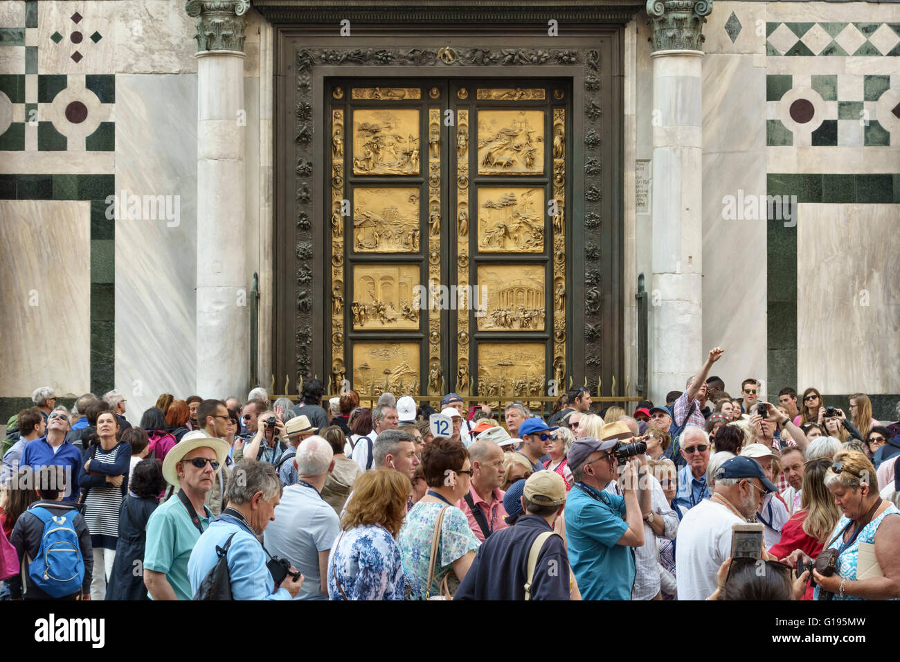 Firenze, Italia. La folla di turisti al di fuori del Battistero, nella parte anteriore del Ghiberti il famoso porte di bronzo (il "Porte del Paradiso", 1425-1452) Foto Stock
