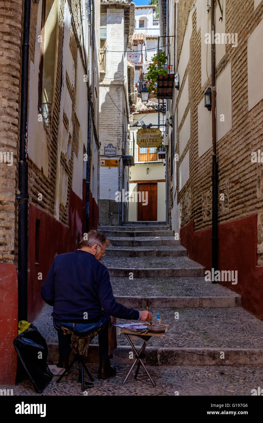 Artista pittura una strada a Granada, Spagna Foto Stock