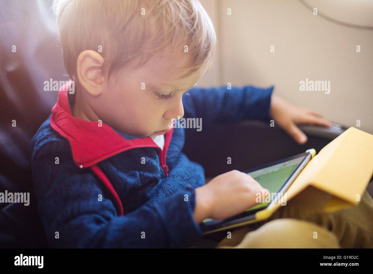 Little Boy utilizzando tablet a bordo dell aeromobile Foto Stock