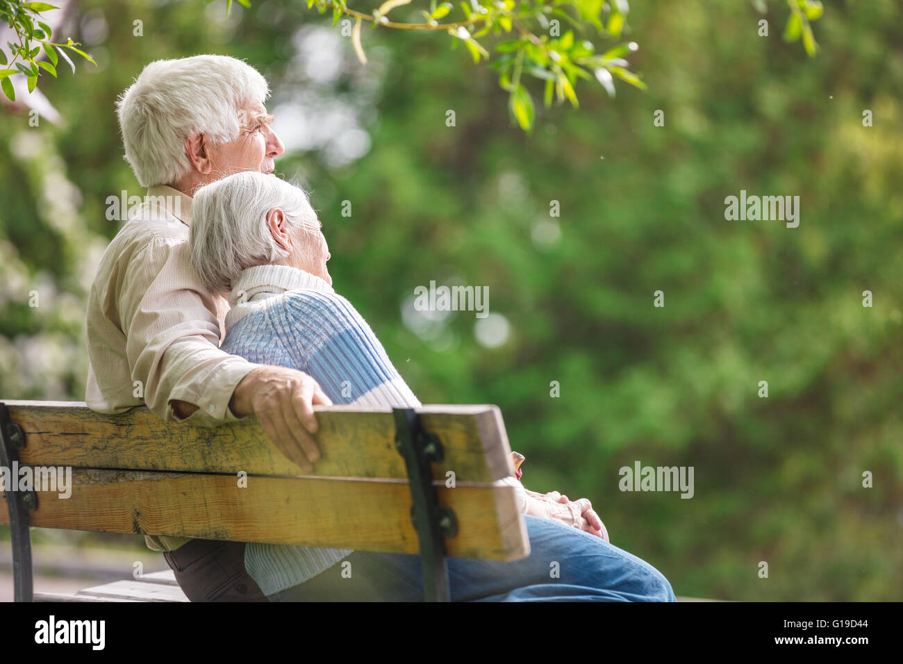 Coppia di anziani in appoggio su una panchina nel parco Foto Stock