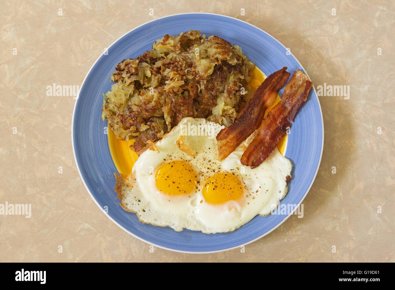 Colazione abbondante piastra con hash browns due uova e pancetta Foto Stock