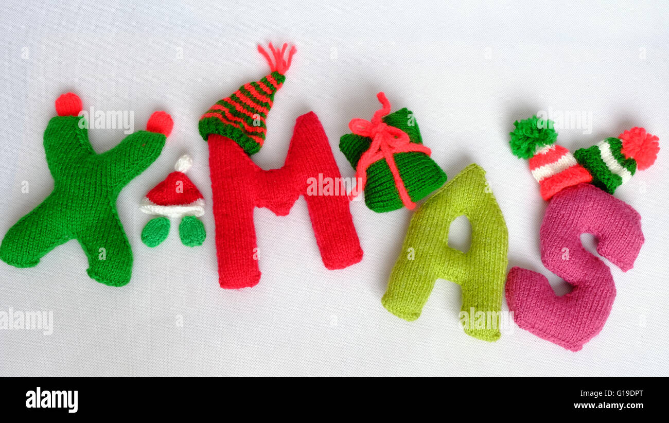 Sfondo di natale, alfabeto natale fatti a mano dalla maglia, incredibile ornamento per noel come lettera, dono, berretto lavorato a maglia da rosso e verde Foto Stock