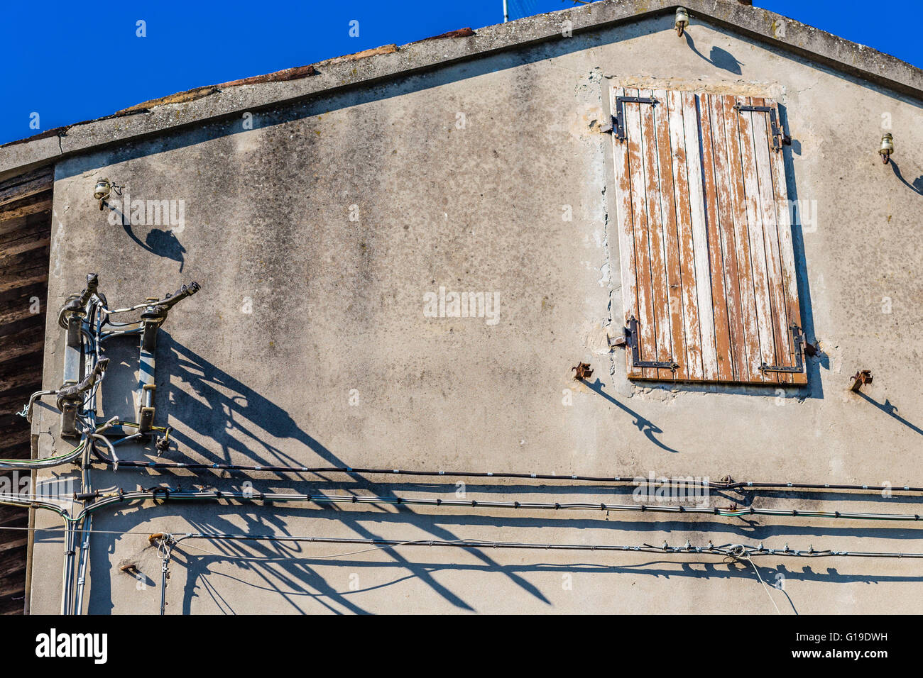 Cavi elettrici e grunge finestra della vecchia casa in un villaggio italiano Foto Stock