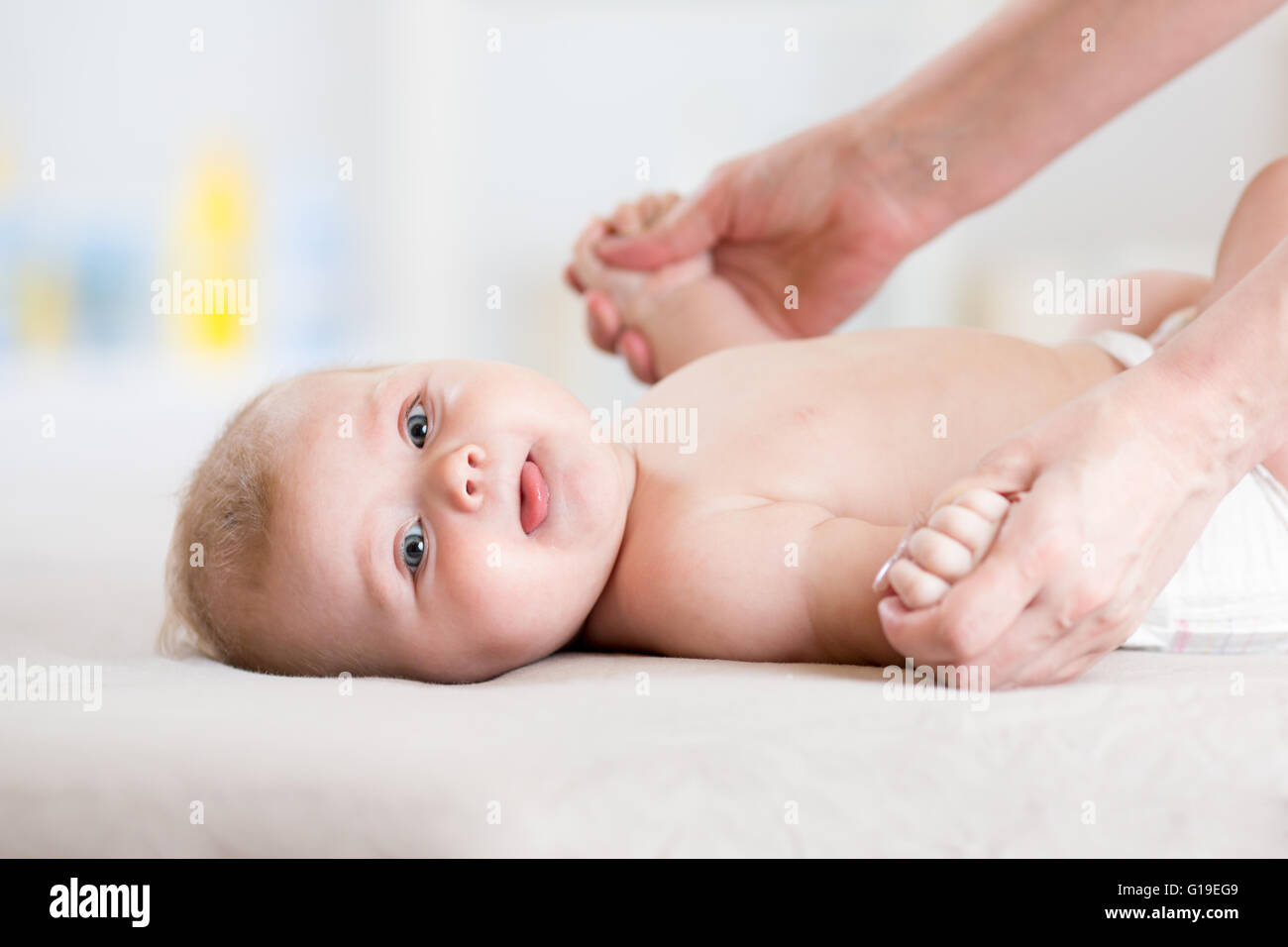 Il bambino di 5 mesi il massaggio. Bambino sdraiato sulla schiena Foto Stock