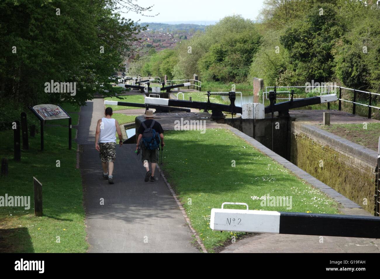 Due persone a piedi lungo la strada alzaia in cima "Delph si blocca su Dudley No1 Canal. West Midlands. Regno Unito Foto Stock