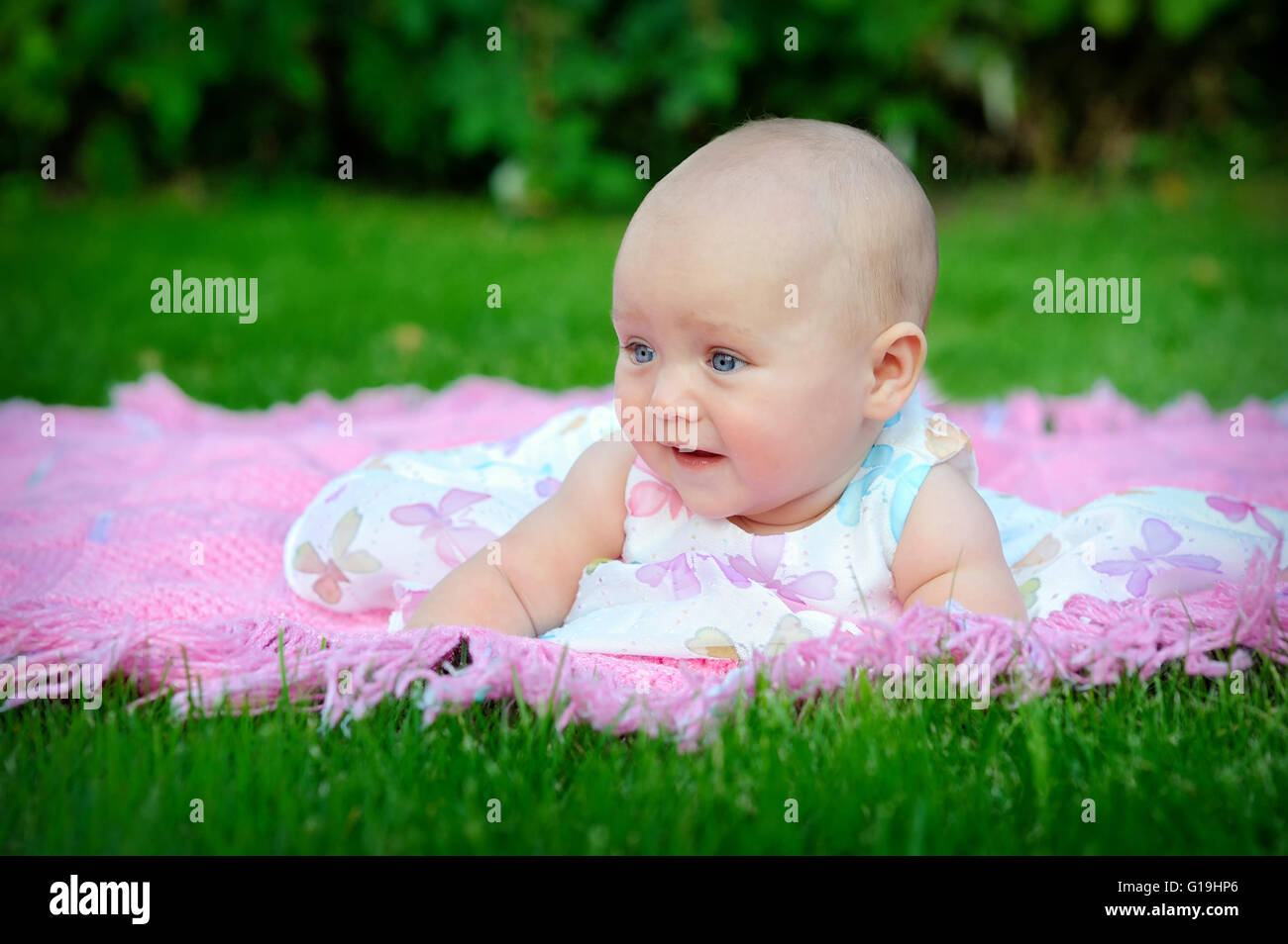 Ritratto di bambina nell'erba all'esterno. Foto Stock