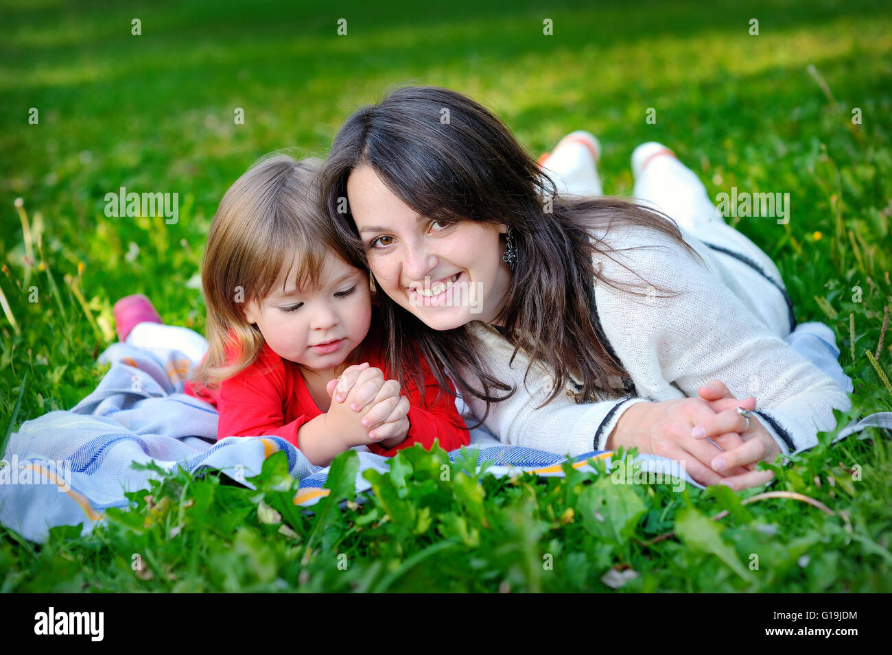 La figlia con la madre sull'erba nel parco Foto Stock