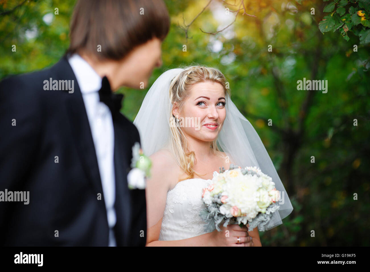 Bella sposa guardando sopra la sua spalla e sorridente Foto Stock