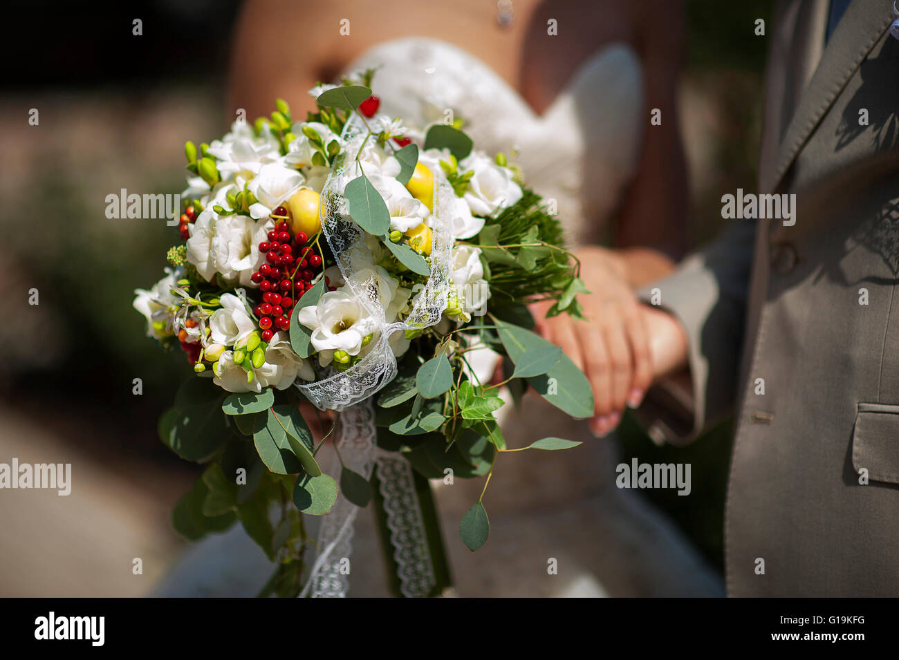 Bouquet nozze di toni di gara nelle mani degli sposi Foto Stock