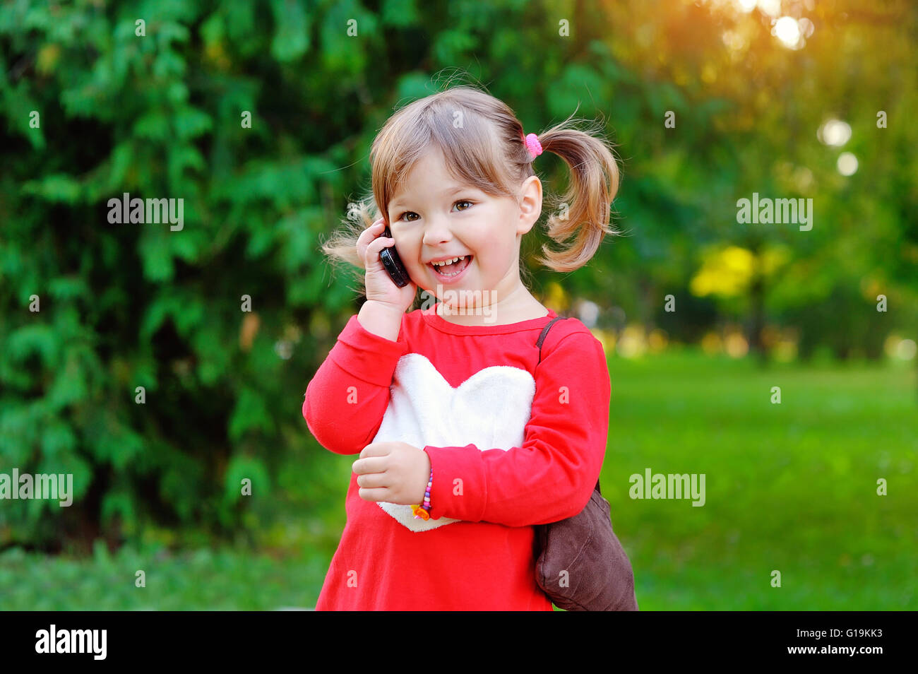 Bambino parla al telefono nel parco Foto Stock