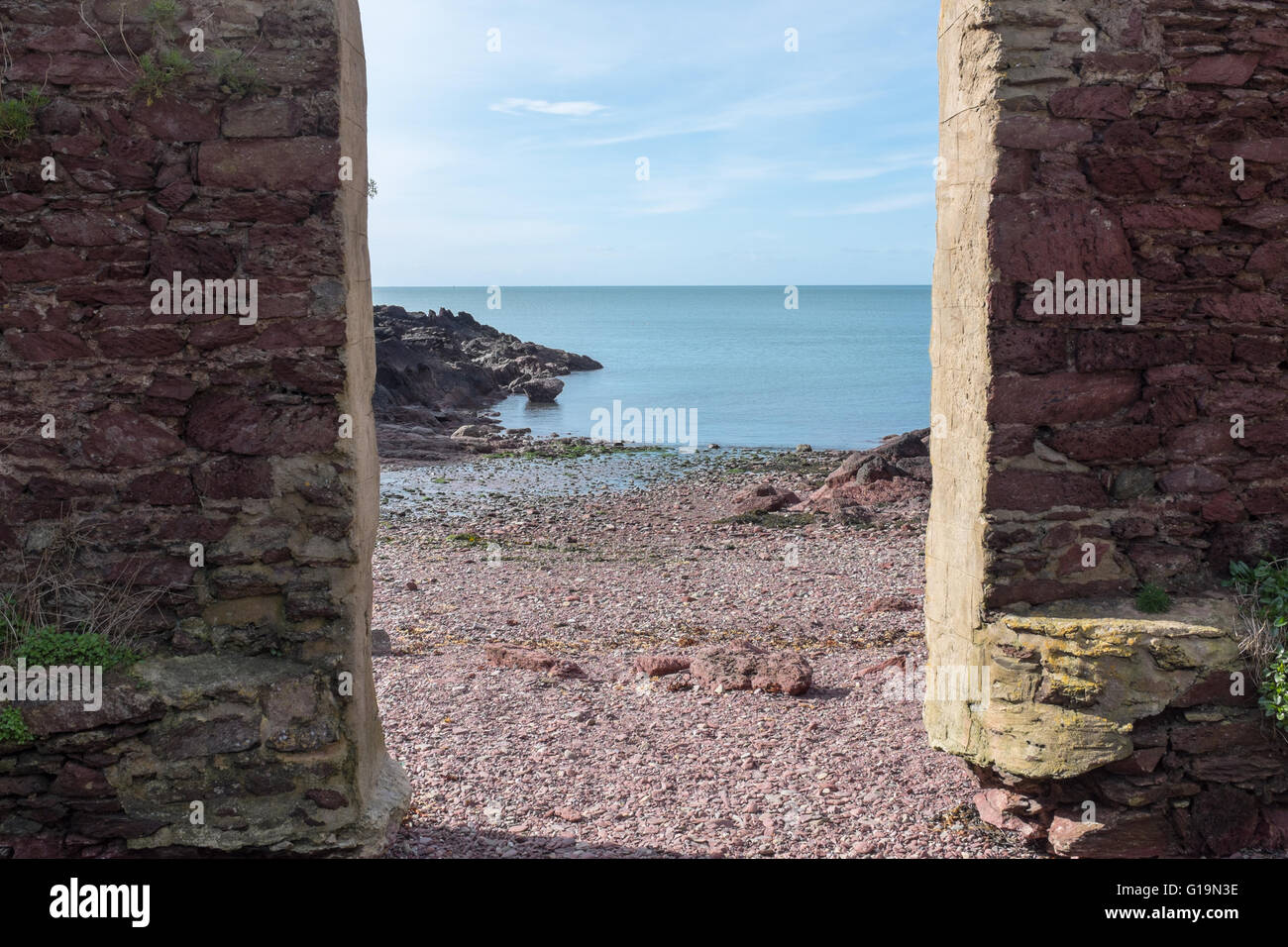 Divario nel vecchio muro di pietra che conduce alla spiaggia sassosa del Pembrokeshire Sentiero costiero Foto Stock