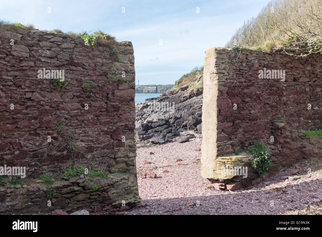 Il vecchio muro di pietra con ingresso alla spiaggia del Pembrokeshire Sentiero costiero Foto Stock