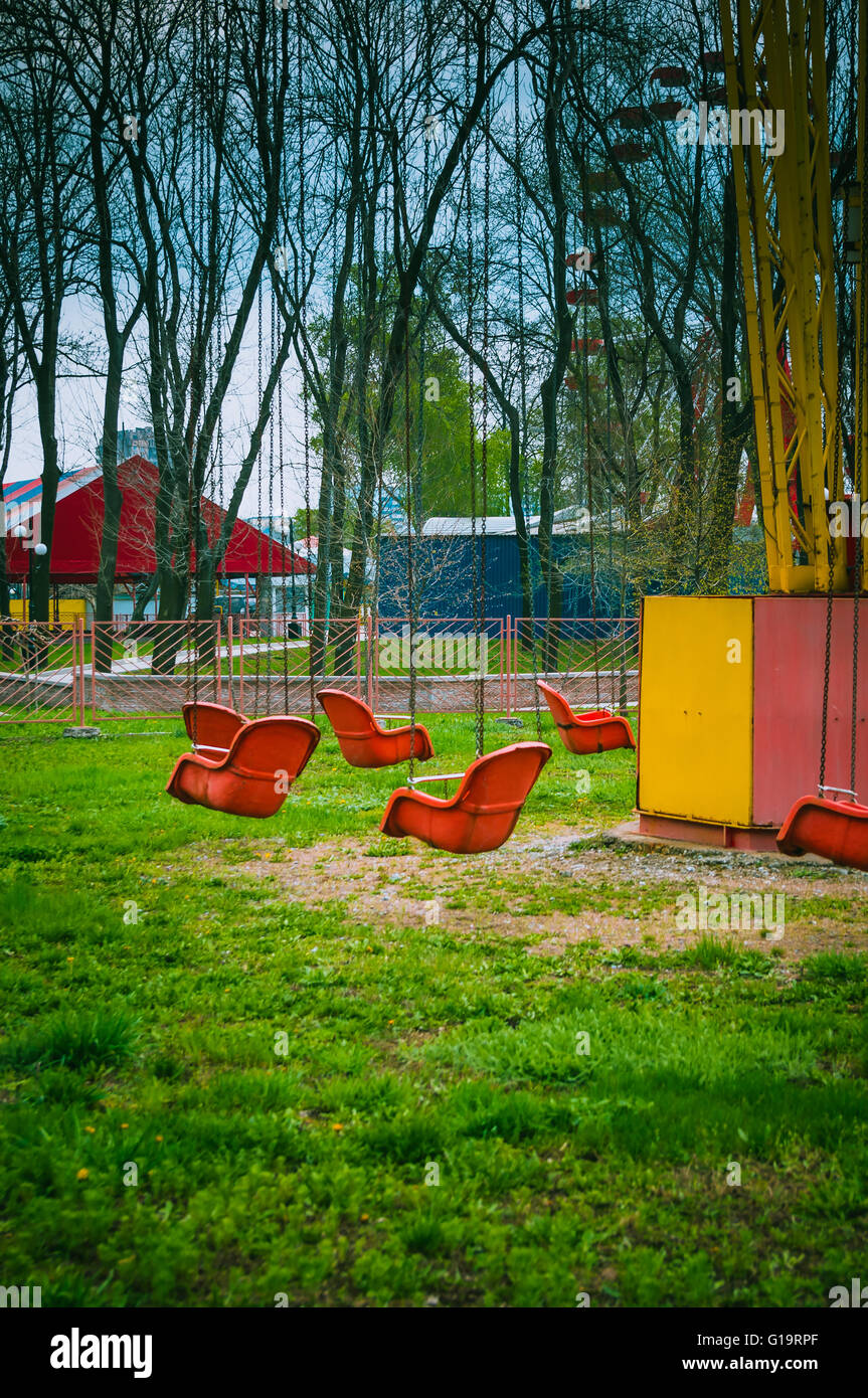 Molla di vuoto il vecchio parco di divertimenti, catena giostra swing attende i visitatori, filtrato per effetto rétro Foto Stock