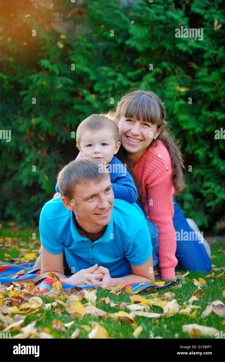 La famiglia felice in autunno park su un prato verde Foto Stock