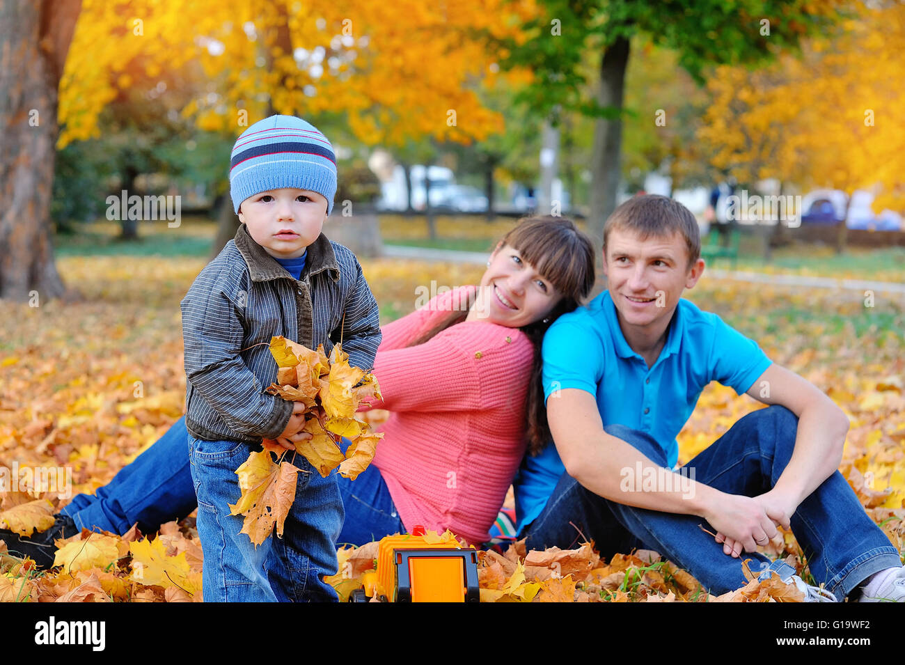 La famiglia felice in autunno park Foto Stock