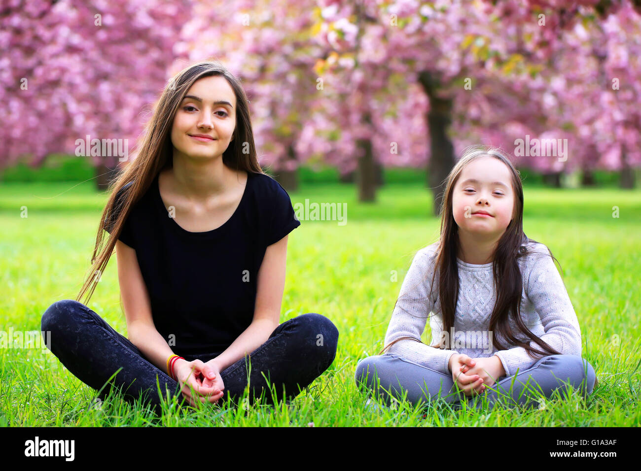 Felice bella giovane donna con bambina in fiore parco con alberi e fiori. Foto Stock