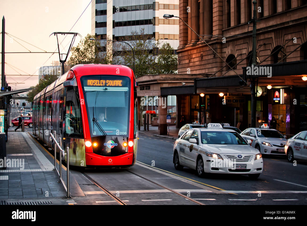 Un tram su una strada vicino a un taxi in Adelaide, Australia Foto Stock
