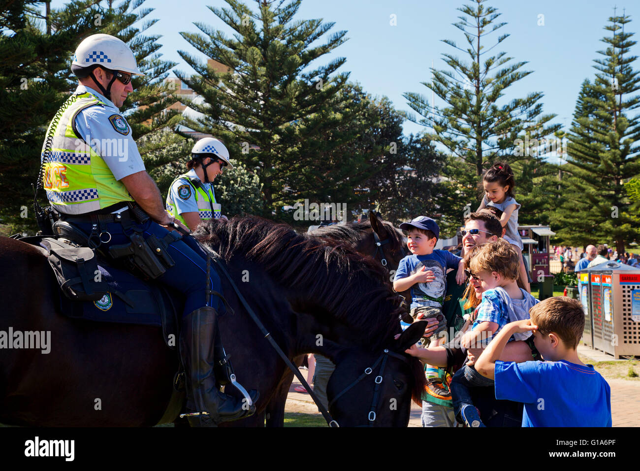 Polizia montata incontrano il pubblico ad una spiaggia torneo di calcio Foto Stock