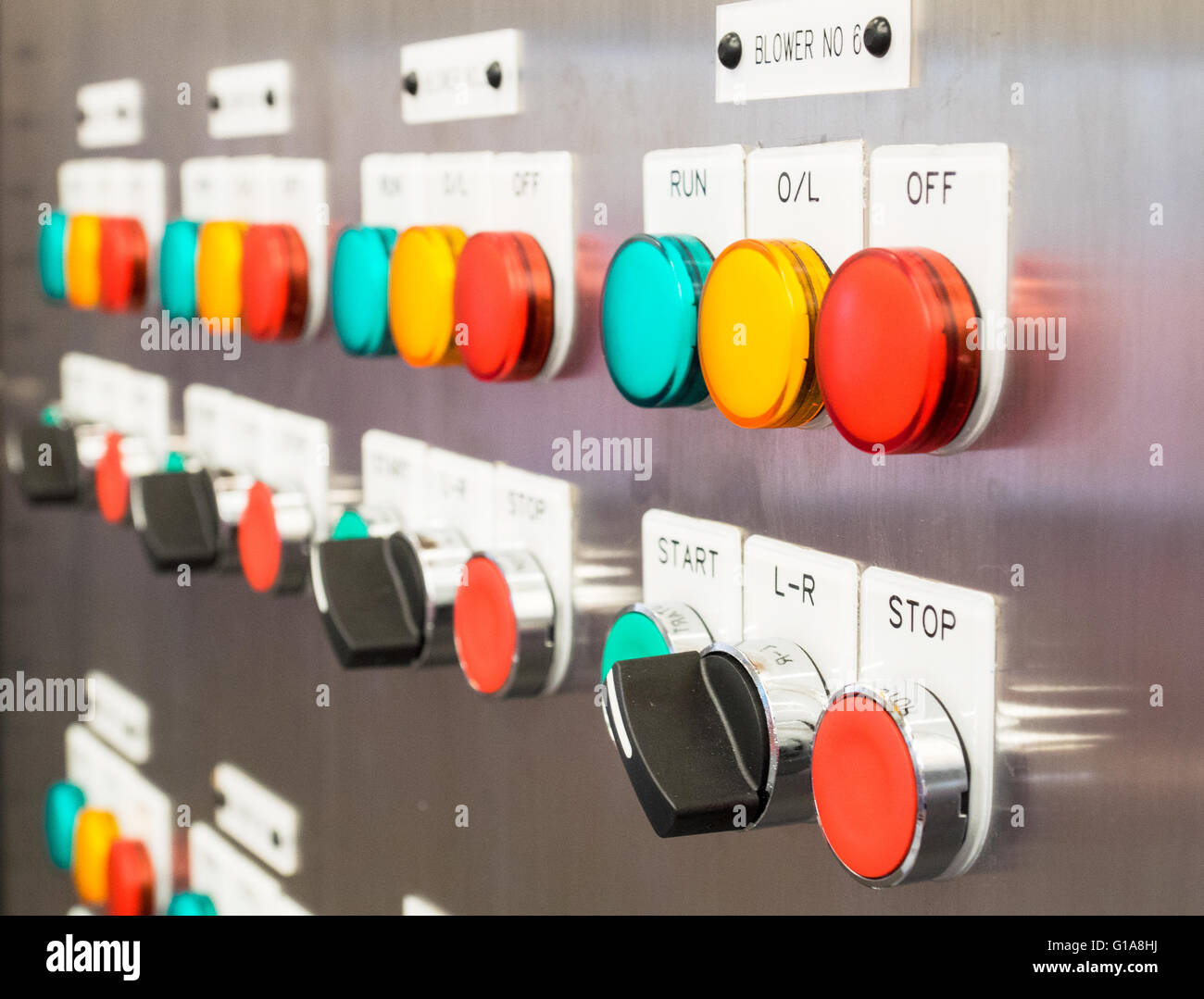 Industriali, interruttore elettrico pannello con i pulsanti in diversi colori. Prospettiva drammatica con profondità di campo ridotta. Foto Stock