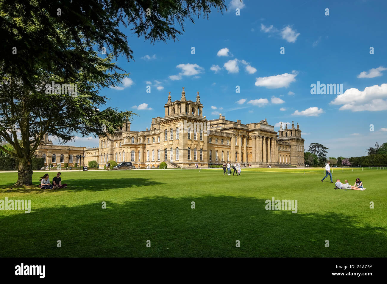 Il Palazzo di Blenheim e visitatori rilassarsi sul prato in una giornata di sole Foto Stock