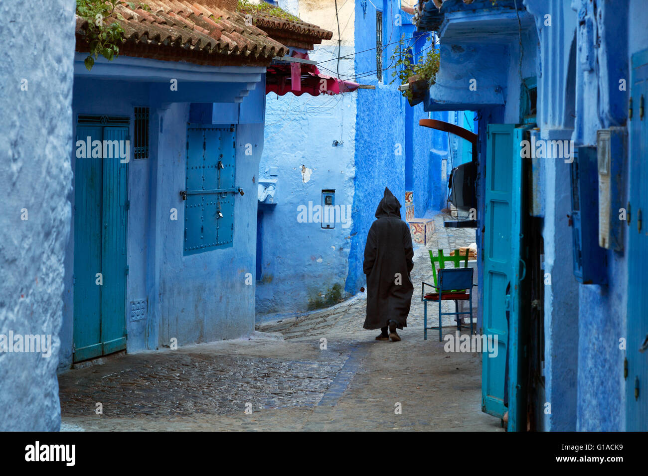 Uomo che cammina nel blu medina di Chefchaouen, Marocco Foto Stock