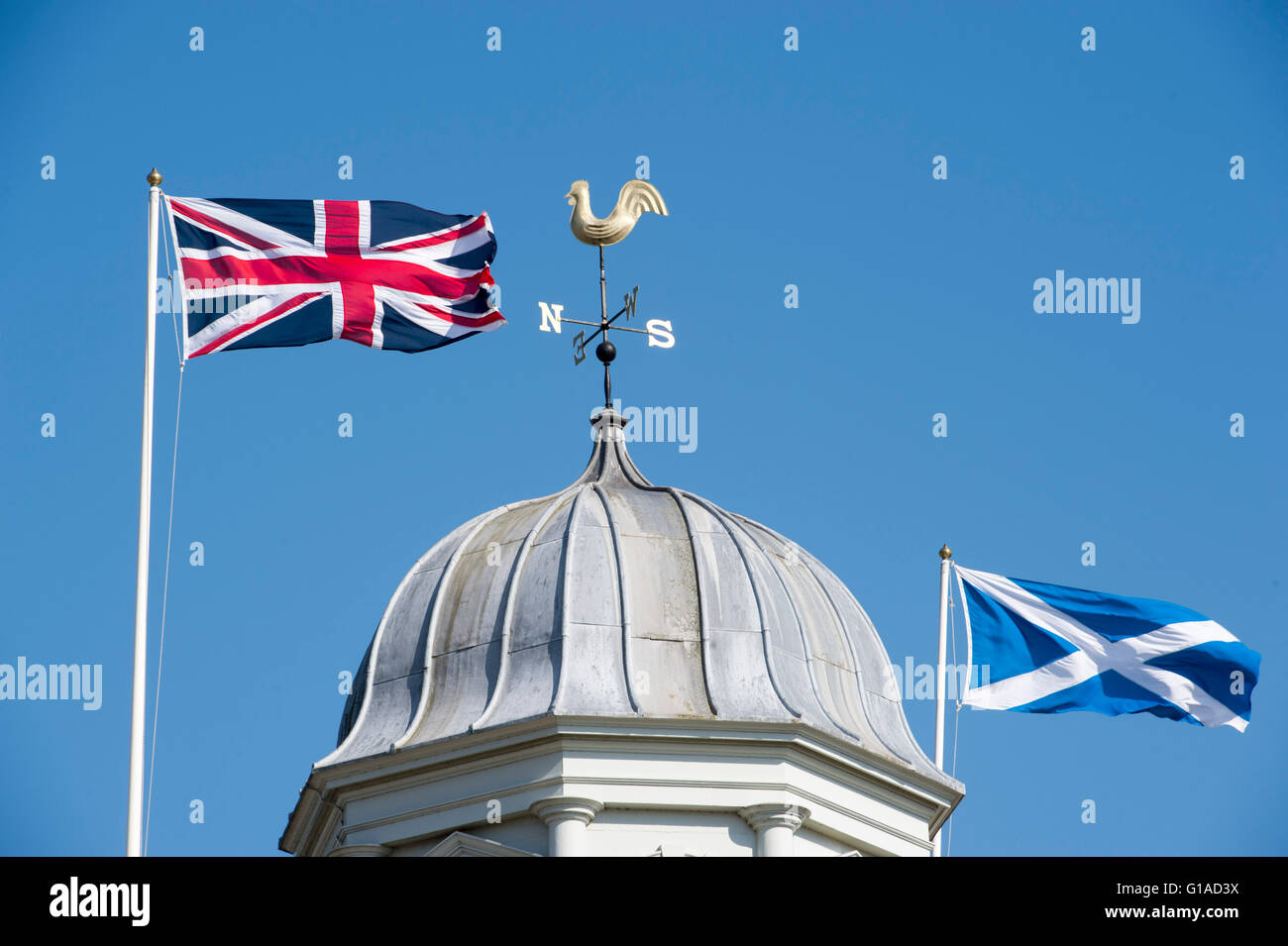 Union Jack e Scottish si intraversa bandiere che sventolano fianco a fianco al di sopra del Municipio di Kelso in Scottish Borders Regno Unito Foto Stock