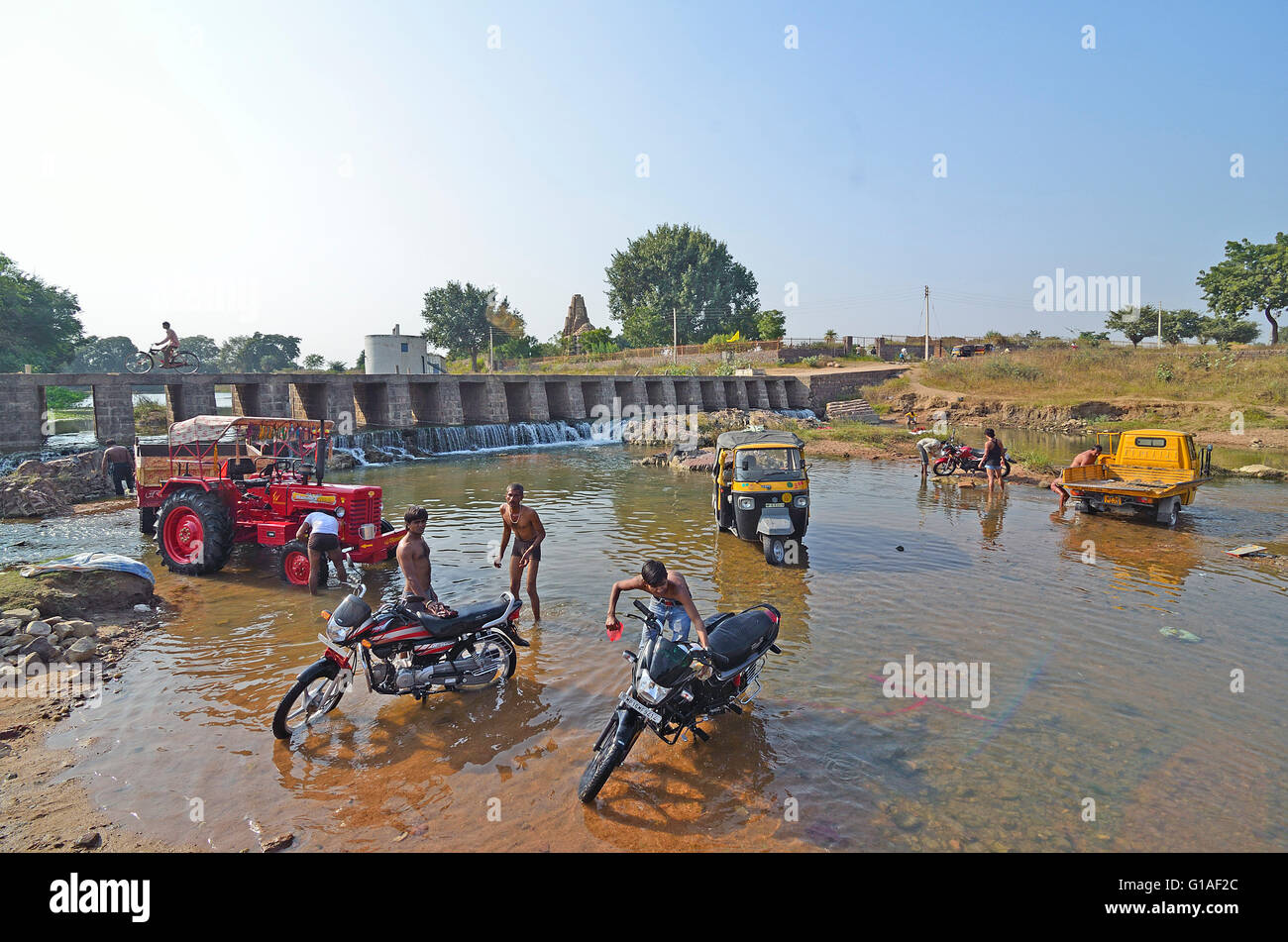 La popolazione locale pulire i loro veicoli in un fiume, Khajuraho, Madhya Pradesh, India Foto Stock